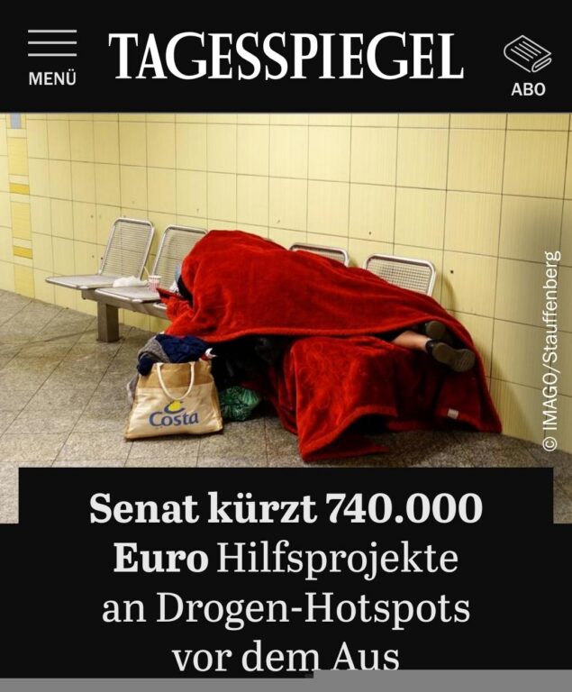 Screenshot Tagesspiegel-Artikel „Senat kürzt 740.000 Euro Hilfsprojekte an Drogen-Hotspots vor dem Aus“ mit Foto einer schlafenden Person unter roter Decke.