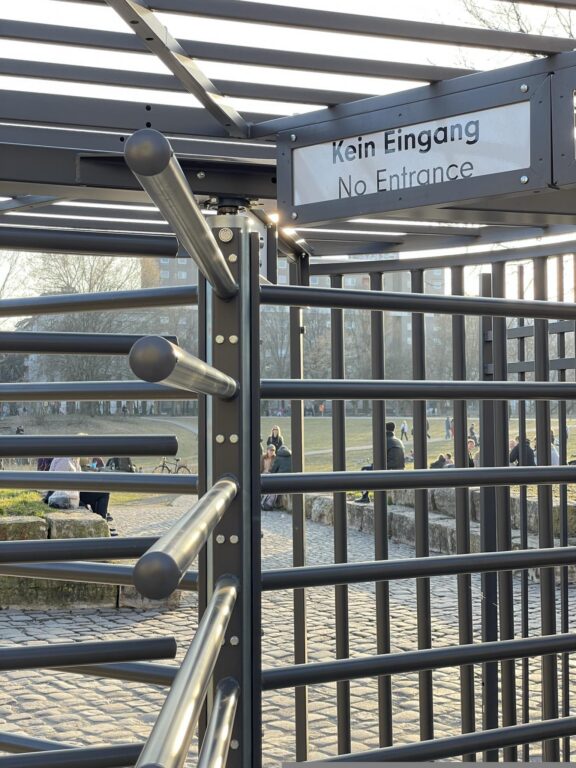 Drehkreuz-Zugangssperre im Görlitzer Park mit Schild „Kein Eingang / No Entrance“, im Hintergrund Parkbesucher*innen.