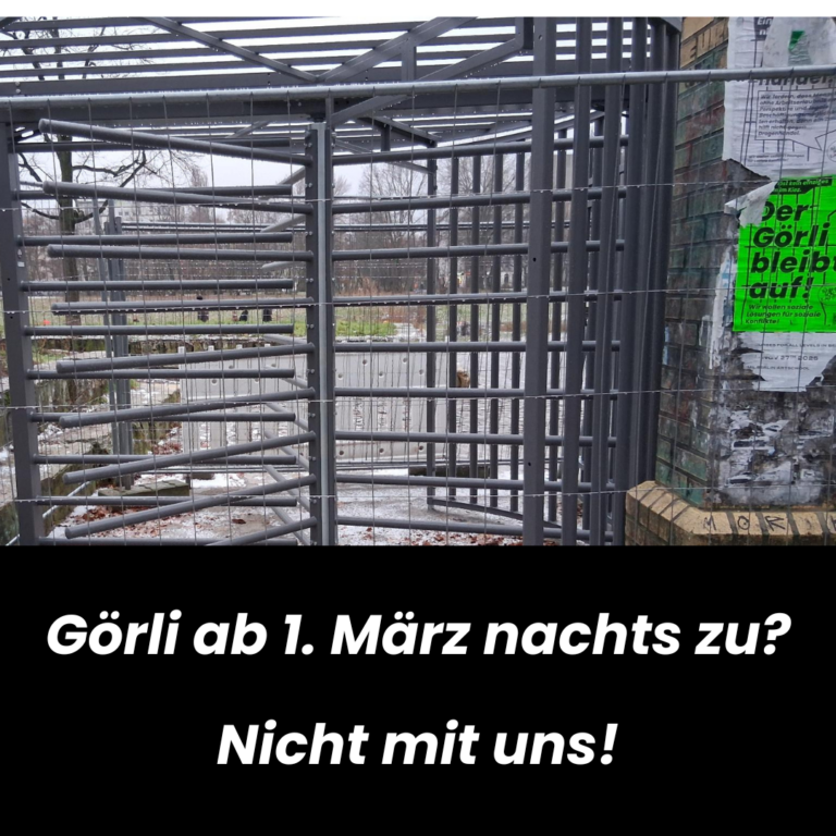 Metall-Drehkreuz im Park, daneben ein grünes Plakat „Der Görli bleibt auf!“. Text: „Görli ab 1. März nachts zu? Nicht mit uns!“