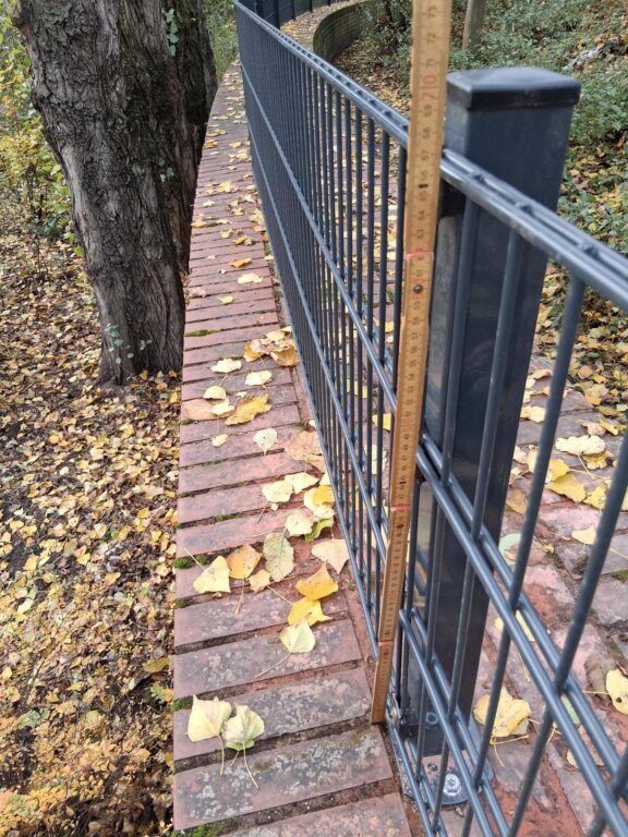 Zollstock misst die Höhe eines Metallzauns am Görlitzer Park auf knapp 70 cm