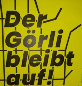 Nahaufnahme eines gelben Aufklebers mit der Aufschrift 'Der Görli bleibt auf!'